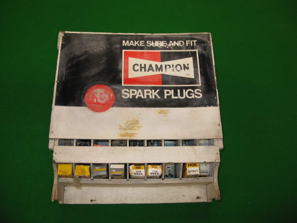 A wall mounted wooden Champion Spark Plug dispenser - 13" x 14.5" with nine storage columns and a