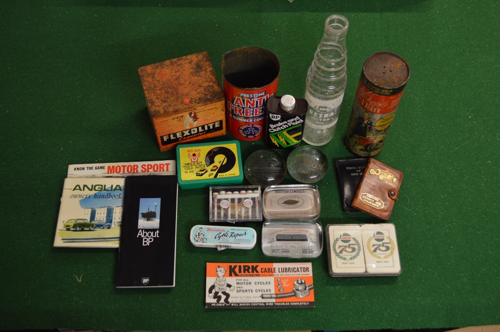 A box containing a quantity of auto related items to include tins, oil bottle, paperweights etc