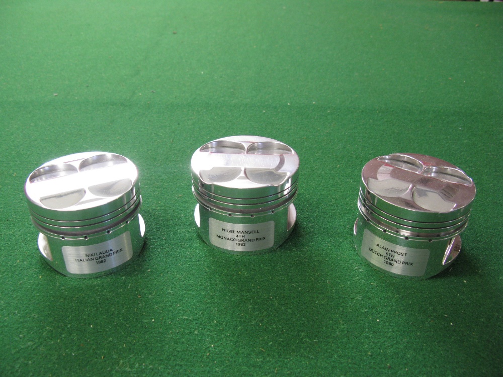 A group of three Cosworth chromium plated pistons inscribed Alain Prost, 6th Dutch Grand Prix