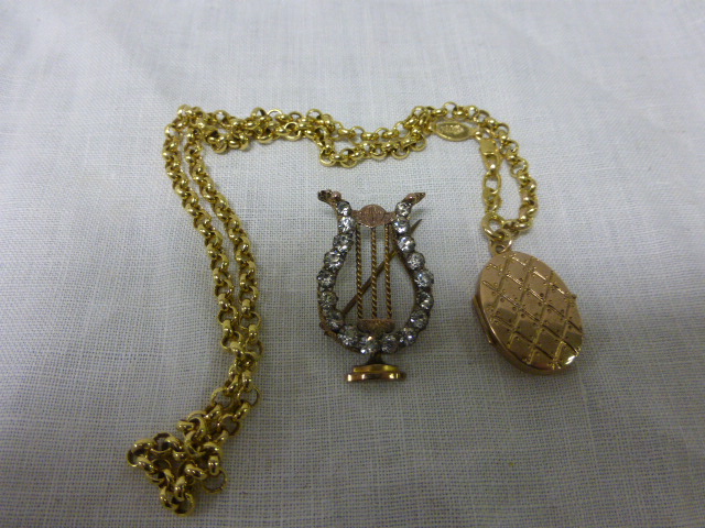 A Yellow Metal Lyre Brooch marked gold and a Yellow Locket and Chain