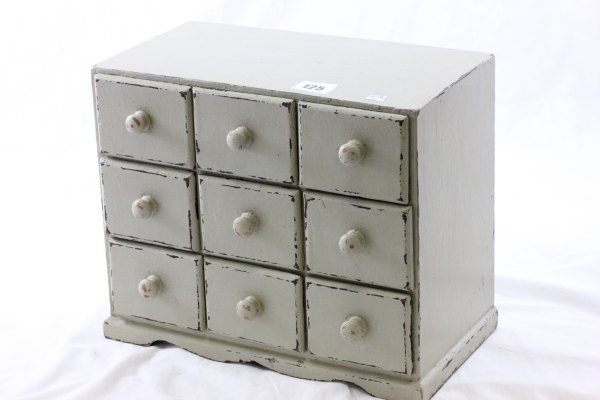 A Painted Table Top Bank of Nine Drawers