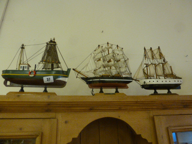 Three model boats on stands including Cutty Sark, Creoula