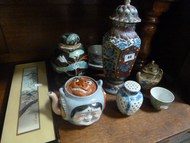 An Oriental Teapot decorated with grotesque faces, a profusely decorated Oriental Lidded Vase and