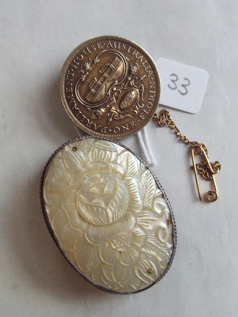 A carved MOP Oriental brooch in silver mount and an Australian coin brooch