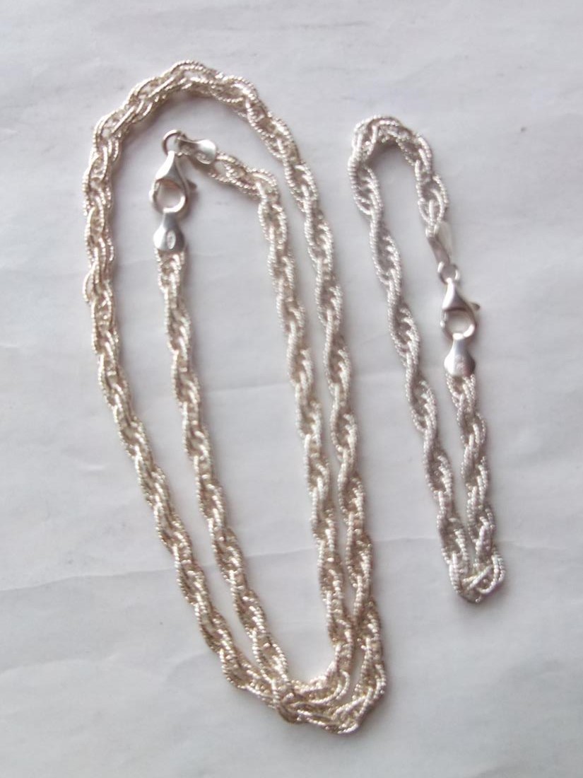 A fancy silver neck chain and matching bracelet