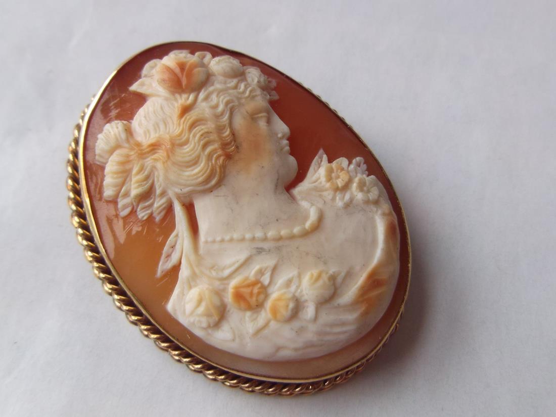 A carved cameo of a lady`s head in gold rope twist mount