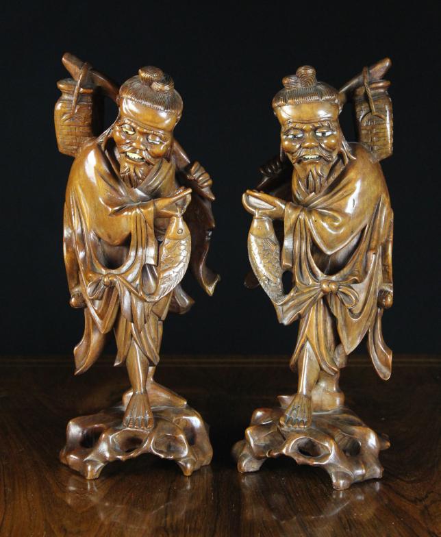 A Pair of Japanese Carvings of Fishermen with bone inset eyes and teeth, 12 ins (31 cms) in height.