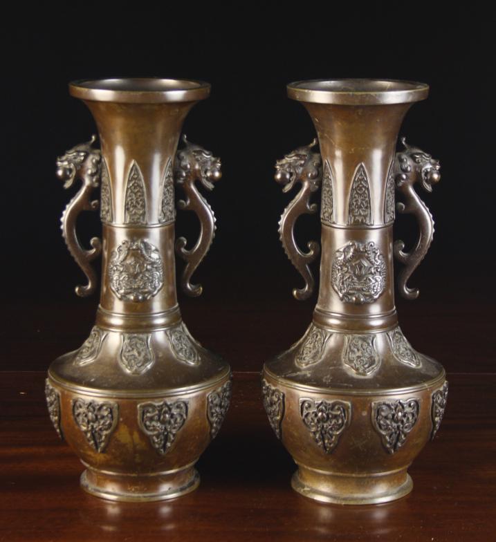 A Pair of 19th Century Oriental Bronze Vases with rich brown patination, dragon handles and relief