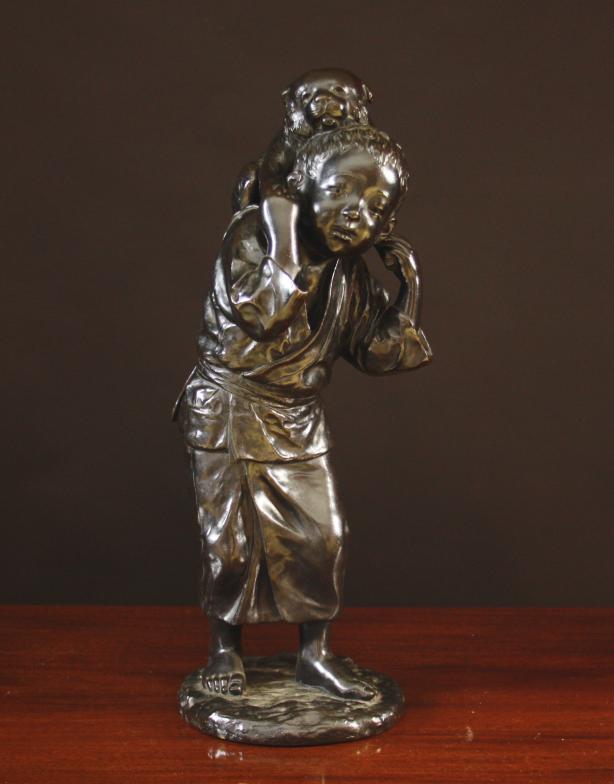 A Large Oriental Dark Patinated Bronze Figure of a bare-foot Boy dressed in a kimono and carrying