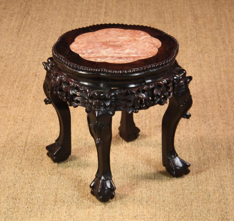 A 19th Century Chinese Hardwood Plant Stand. The petalled top having a pink marble insert and beaded