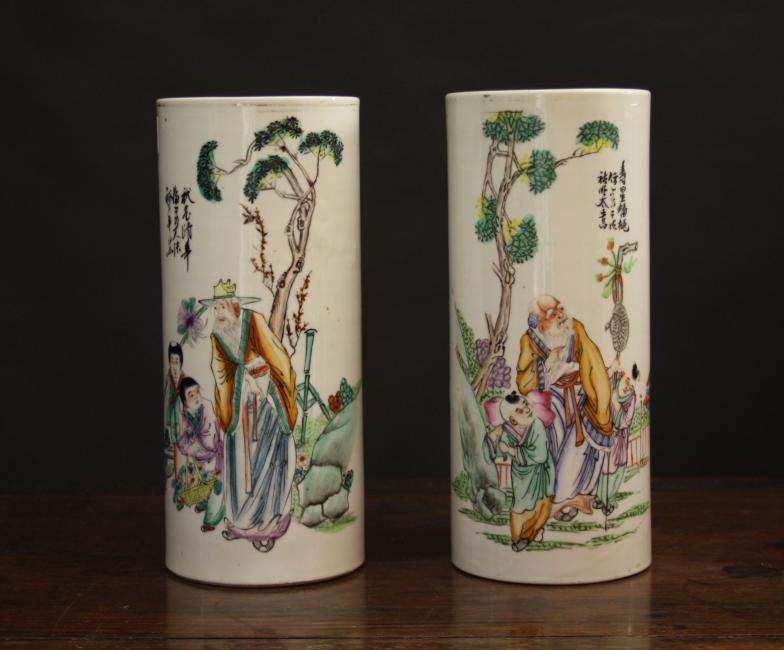 A Pair of Oriental Brush Pots.  The cylindrical vessels painted with calligraphy and figural scenes;