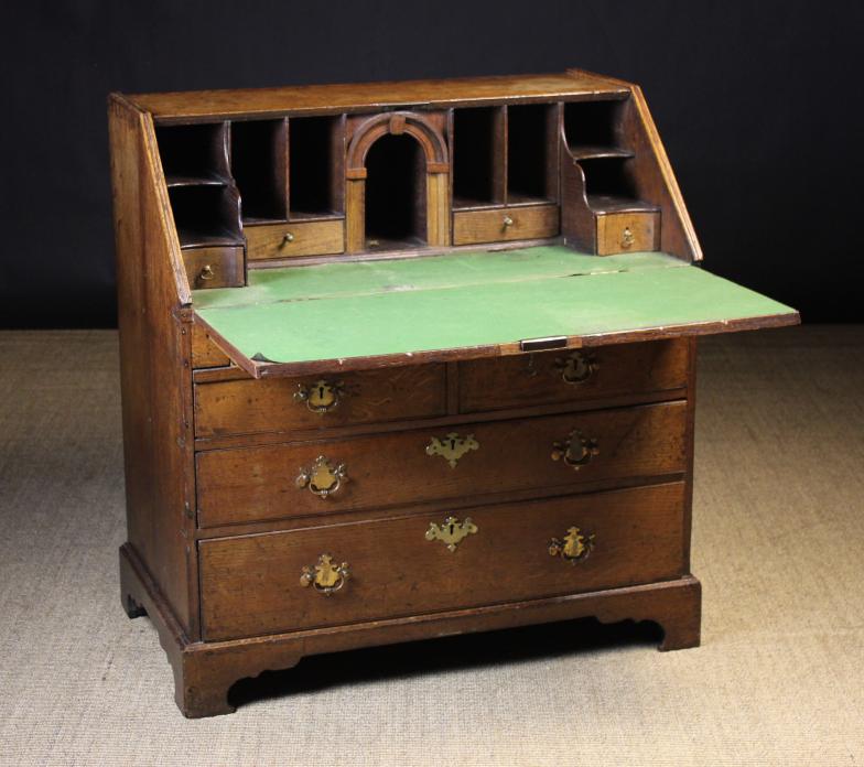 A George III Oak Fall Front Bureau.  The sloped front opening on loper supports to reveal a baize