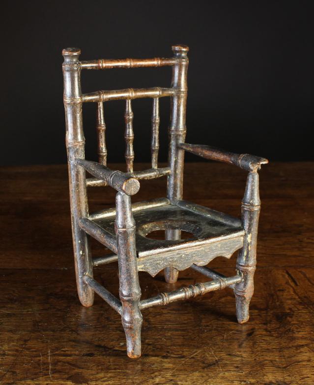 A 19th Century Miniature Commode Armchair. The back composed with turned faux bamboo spindles and