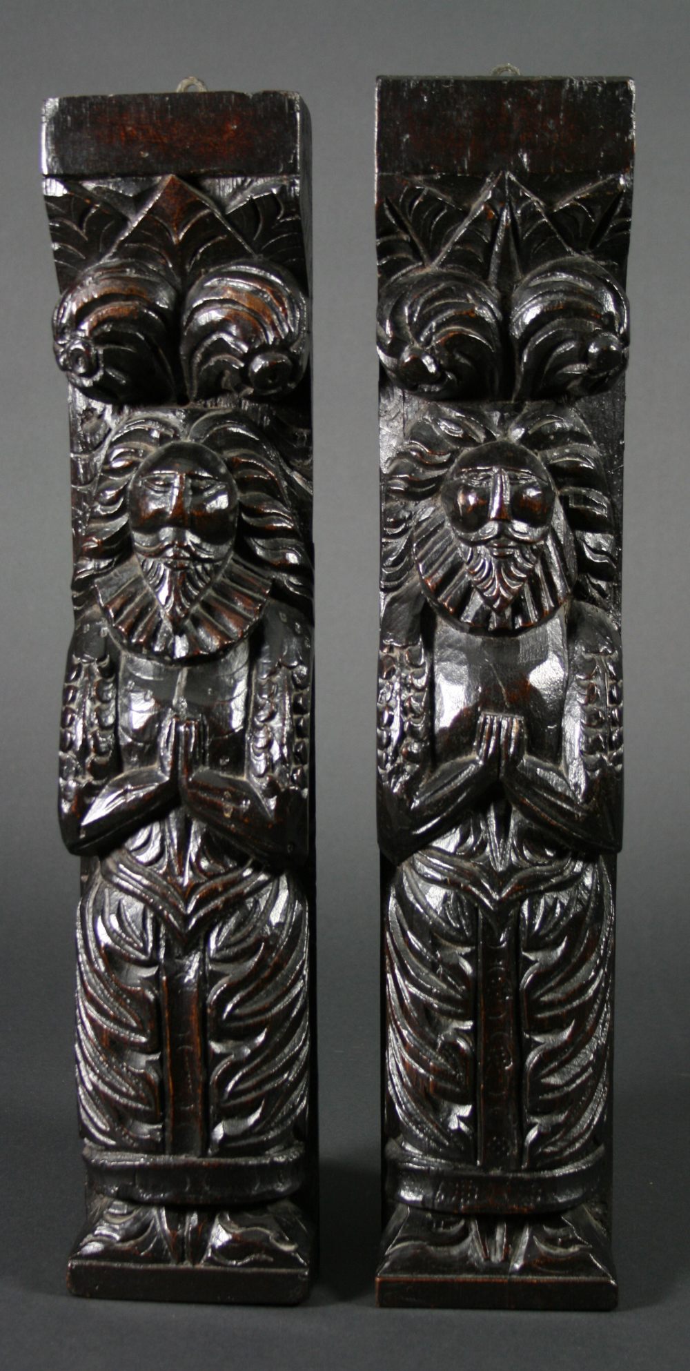 A Pair of Carved James I Oak Atlantes. The bearded figures having outswept hair and wearing high