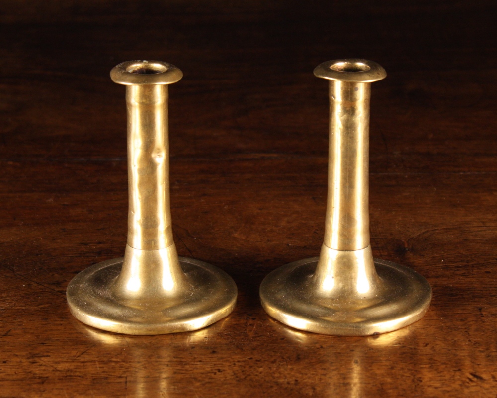 A Pair of Late 17th Century Brass Candlesticks. The cylindrical stems with flanged integral sockets,