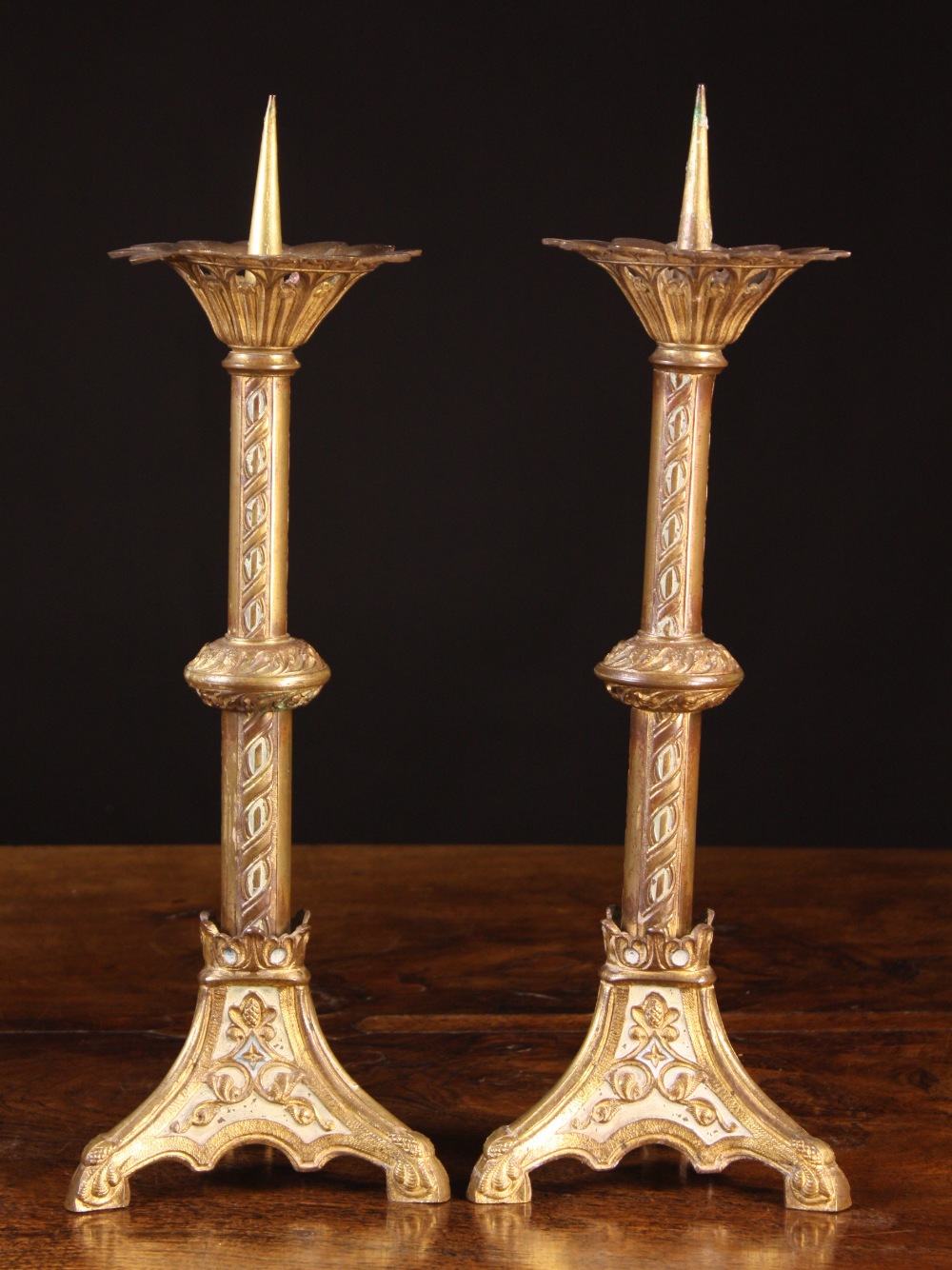 A Pair of Neo-Gothic Gilt Metal Pricket Sticks.  The pierced petal-edged drip pans on knopped