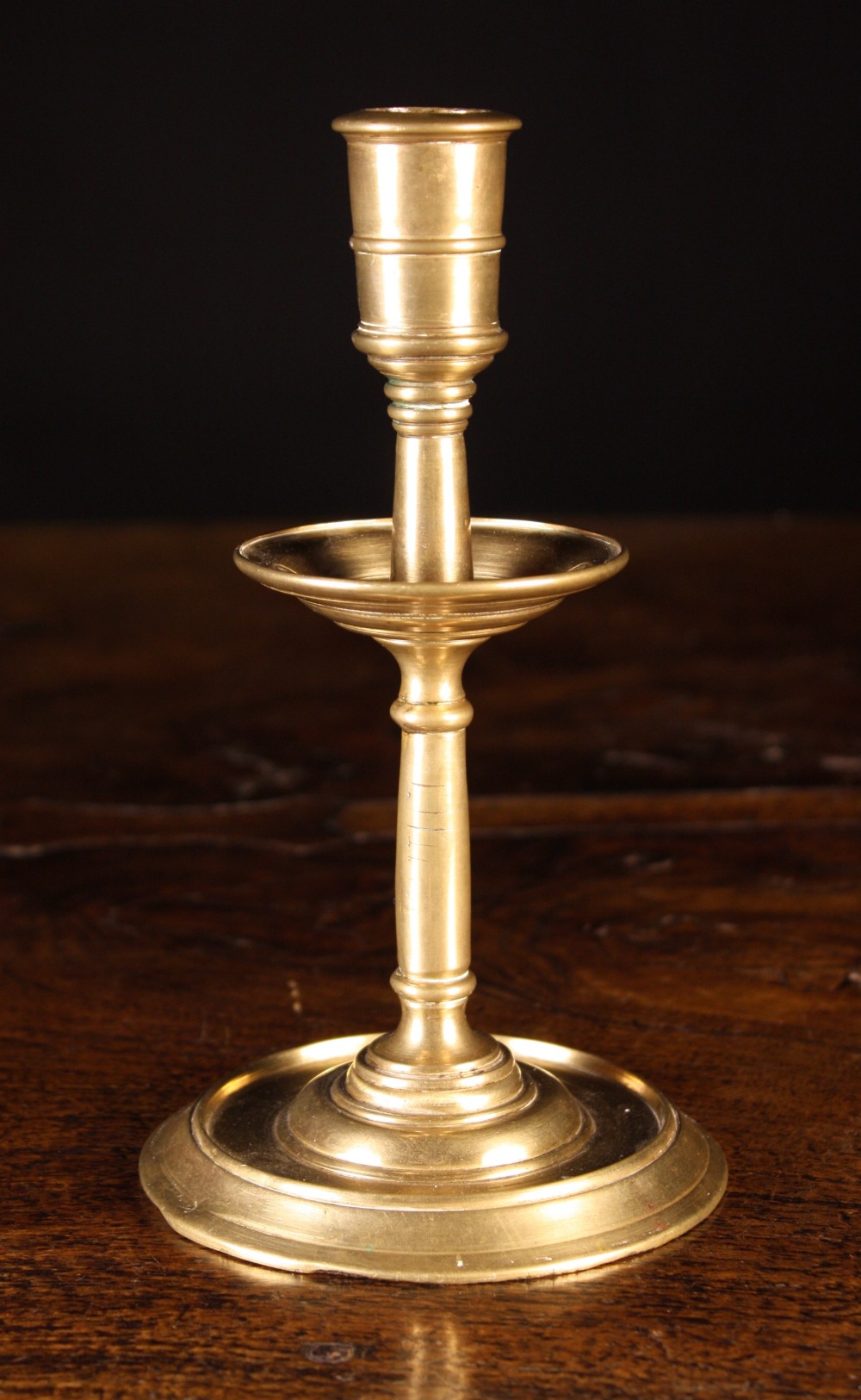 A 17th Century French Candlestick.  The candle cup on integral stem with mid drip pan and flat