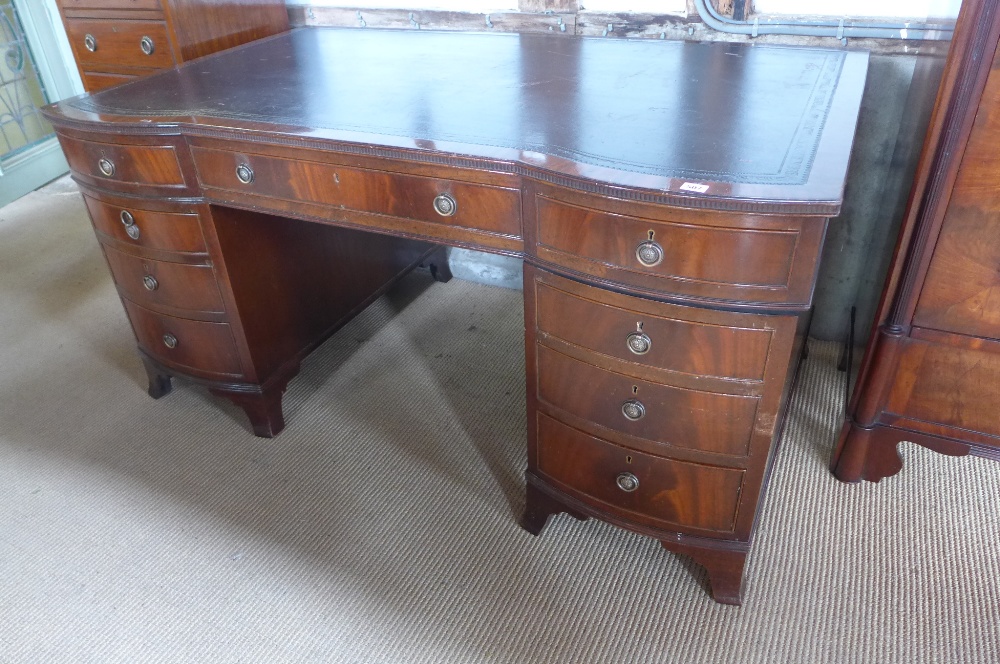 A Georgian style mahogany twin pedestal double bowfronted nine drawer desk with a leather inset