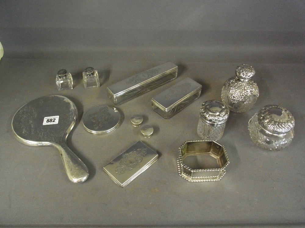 A selection of five silver top bottles, two silver top tidies, a silver back mirror, four silver