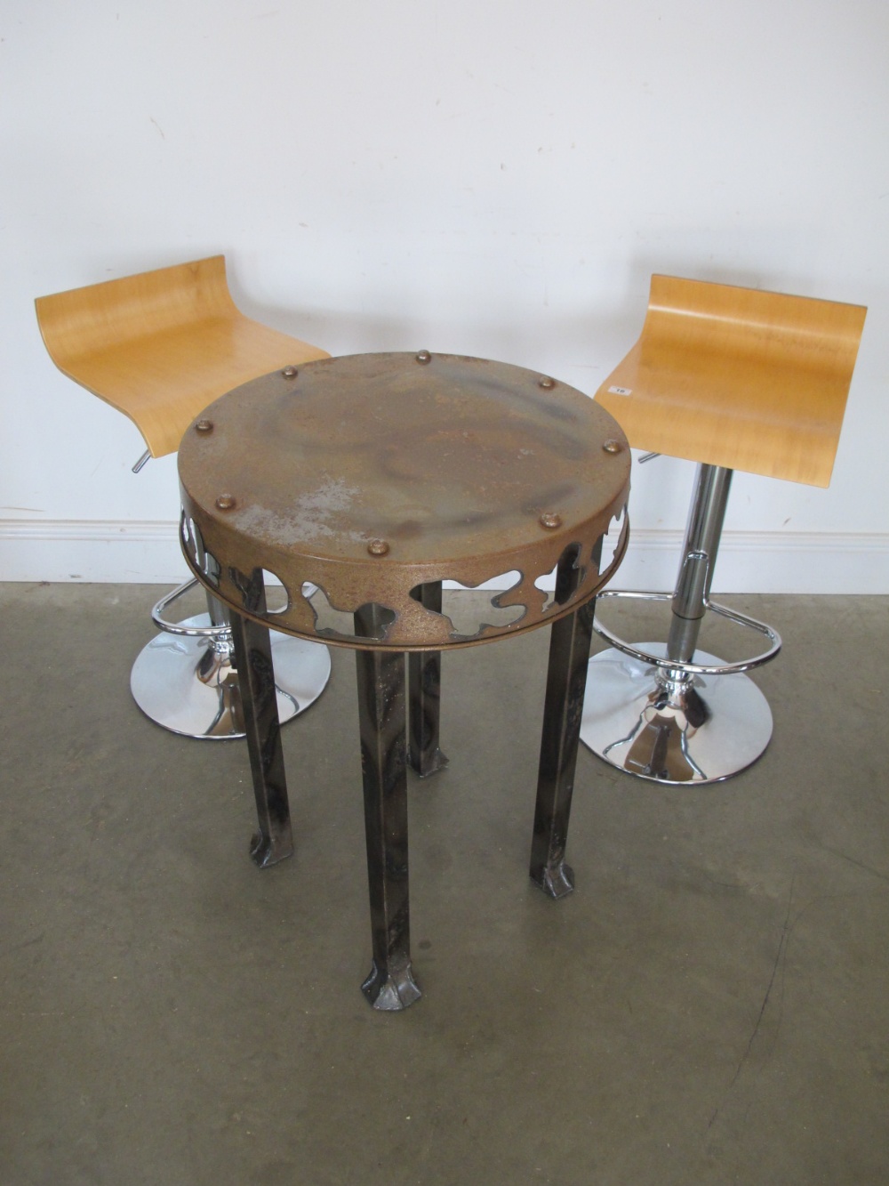 A pair of modern chrome and beechwood bar stools and a modern metalwork table