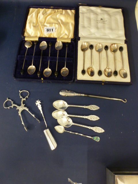 Two boxed sets of silver coffee spoons, five other silver spoons, a silver handled button hook and a