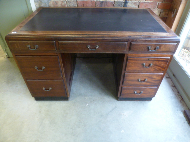 A 1930's mahogany desk with a leather inset top over eight drawers - Height 79cm x Width 130cm x