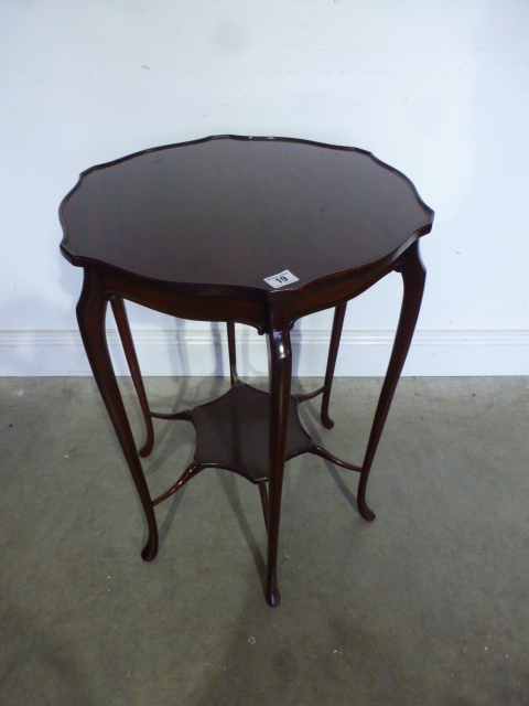 A mahogany side table with a shaped top