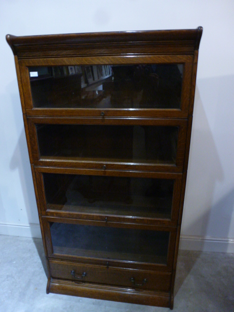 An oak four section Globe Wernicke style stacking glazed bookcase with a base drawer - Height 1.