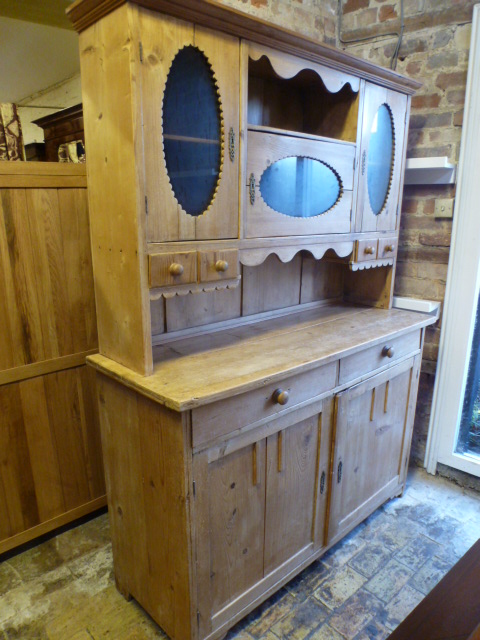 A Continental pine dresser with a glazed top and four small drawers, the base with two drawers and