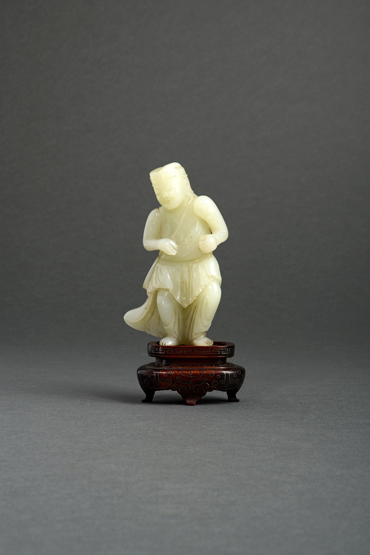 A Chinese pale celadon jade carving of a man, probably Yuan dynasty, in Western dress standing