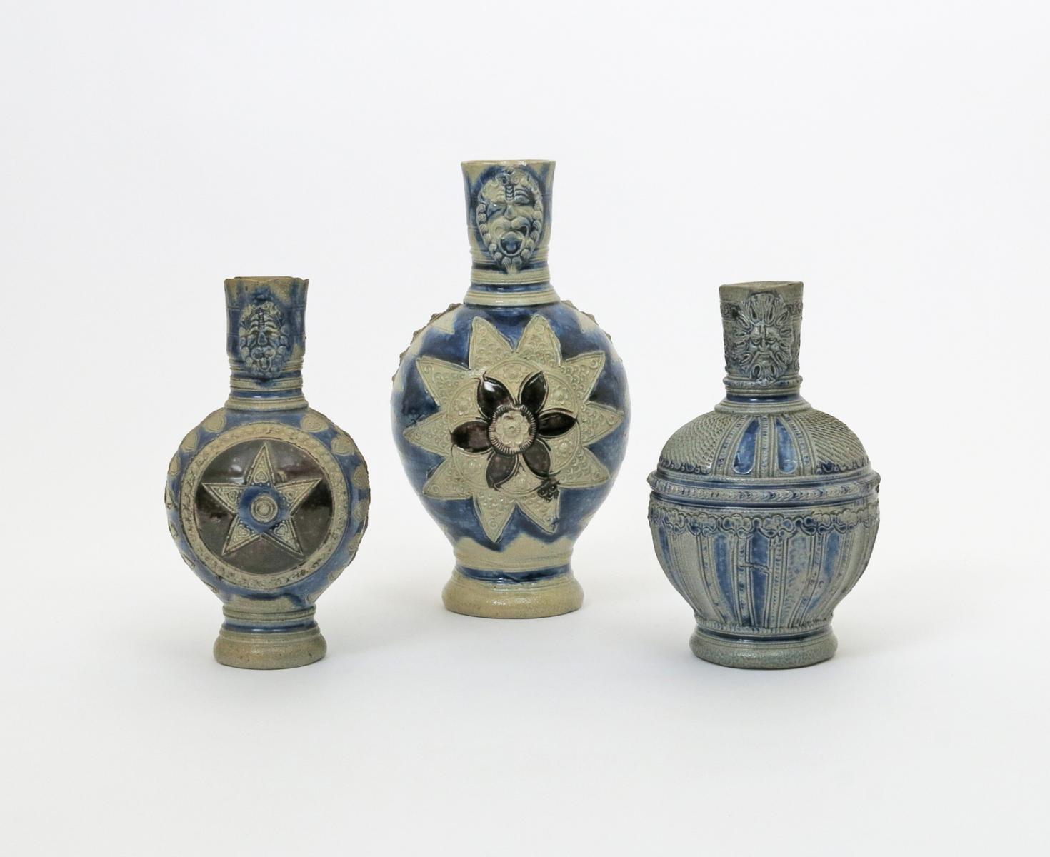 Three Westerwald stoneware mask jugs, 17th/18th century, two decorated with a large star-shaped