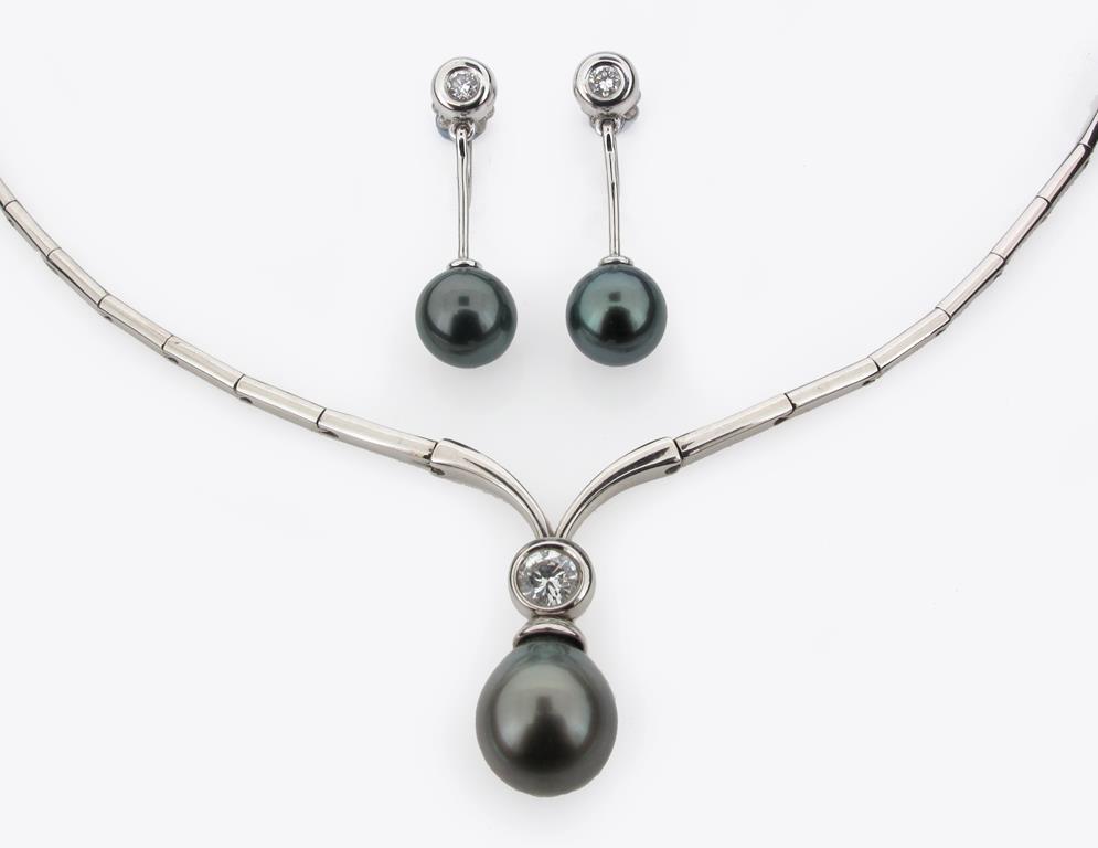 An articulated white gold necklace suspending a black cultured pearl and a circular cut diamond,