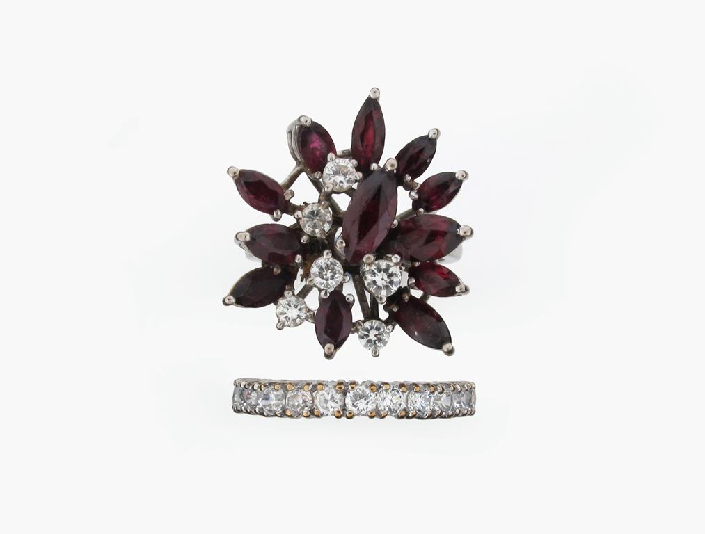 A ruby and diamond cluster ring, set with marquise shaped rubies and circular cut diamonds in