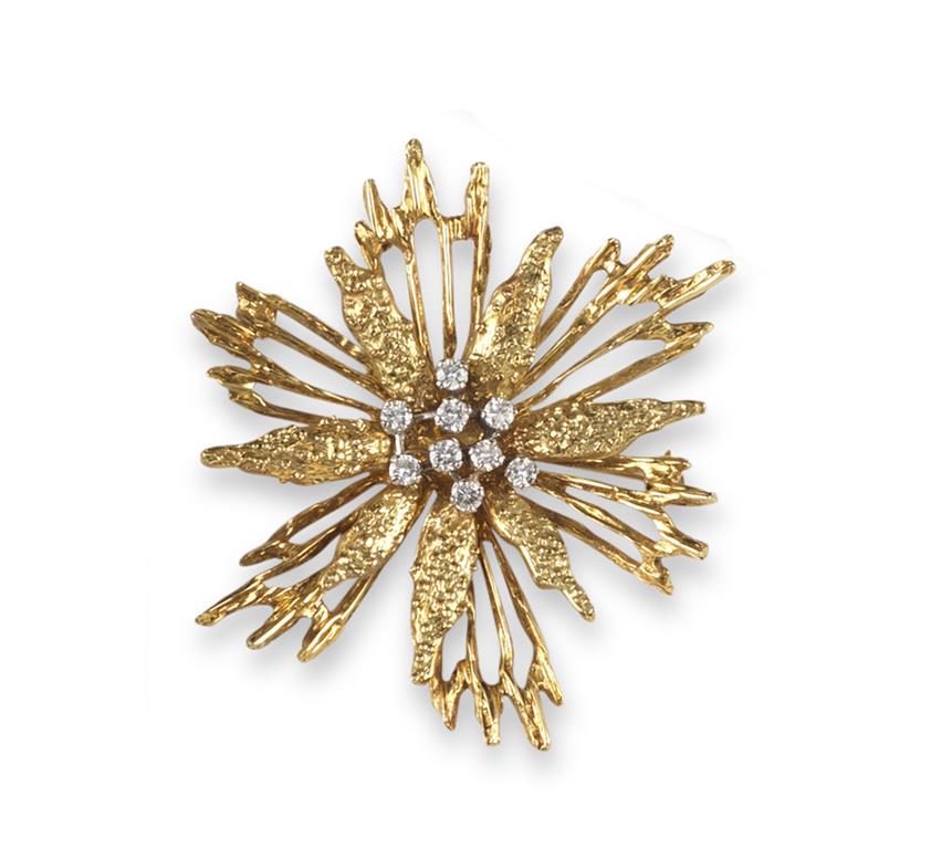 A diamond set starburst design yellow gold brooch, centred with nine small circular cut diamonds.