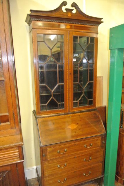An inlaid Edwardian mahogany bureau bookcase, the bureau fitted with three long drawers, the fall