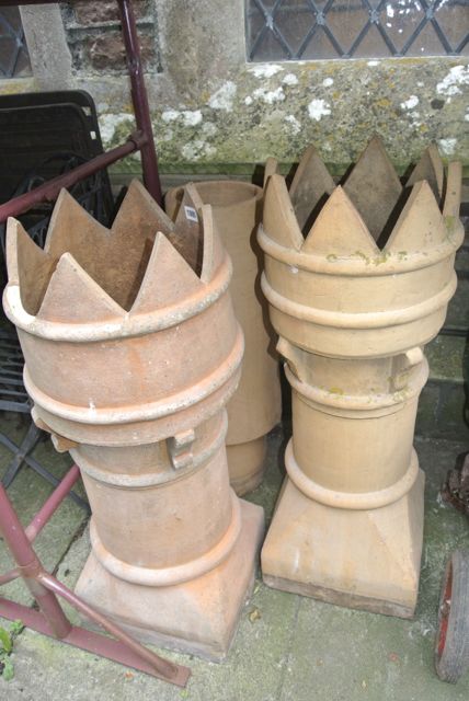 Two similar reclaimed buff coloured terracotta crown top chimney pots together with one other