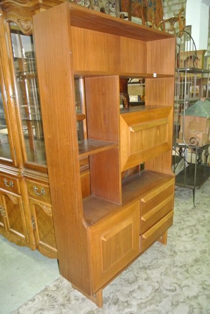 A retro teak freestanding side cabinet/lounge unit enclosed by cupboards and drawers flanking open