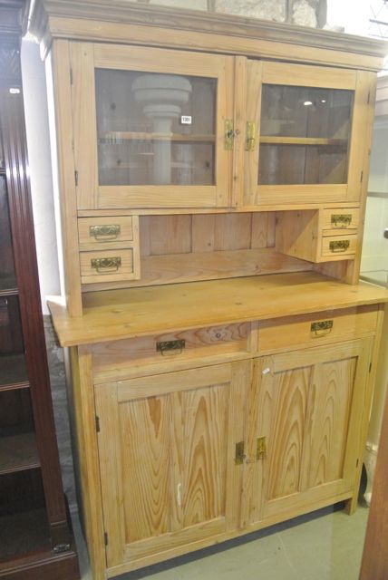 A continental stripped pine kitchen dresser, the upper section with moulded cornice over a pair of