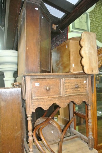 An oak drop leaf side table with two deep frieze drawers raised on turned column supports united by