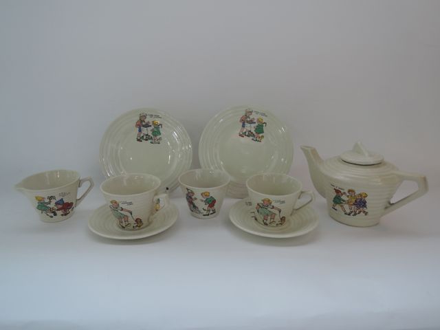 A child`s tea-for-two set with transfer printed nursery rhyme decoration on a rib moulded cream