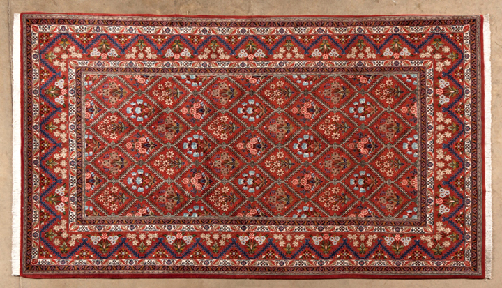 A QUM CARPET, PERSIA, MODERN the madder-red field with a trellis pattern containing multicoloured