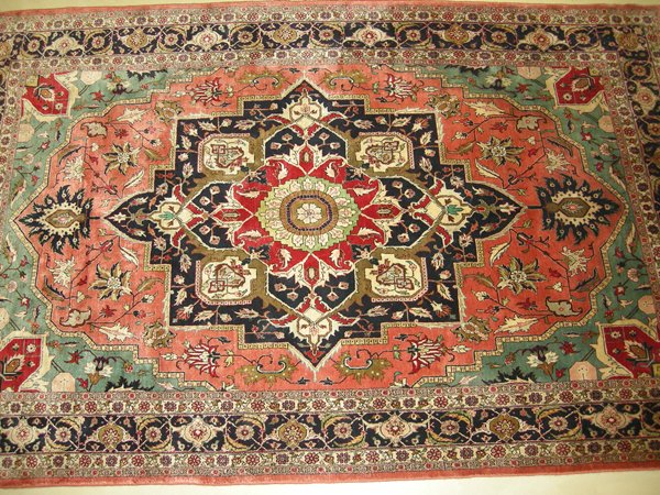 A Heriz Silk Carpet, N.W. Persia, modern the salmon field with a styalised bold stepped floral