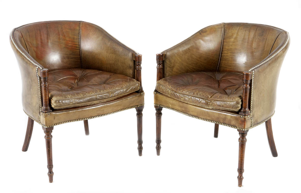 A pair of Georgian leather upholstered and mahogany tub chairs each with a studded curved back,