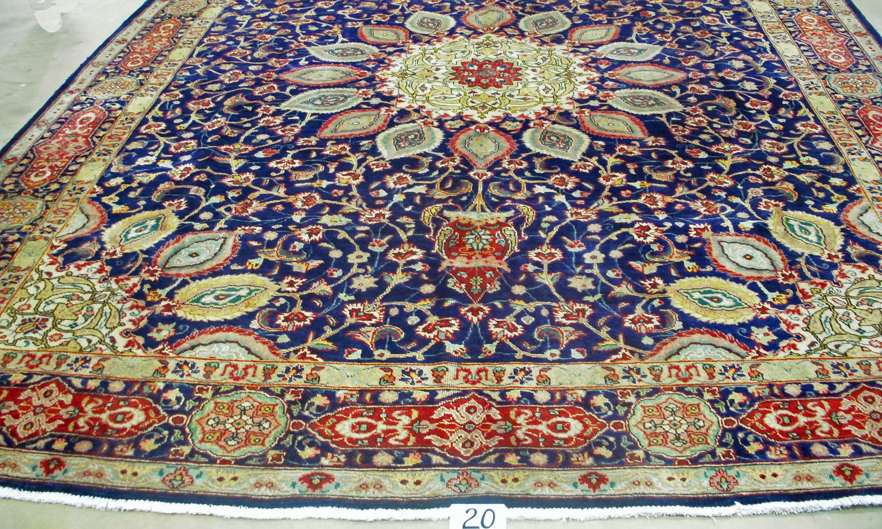 A FINE TABRIZ CARPET, PERSIA  a circular medallion on a midnight blue field with sixteen ogee