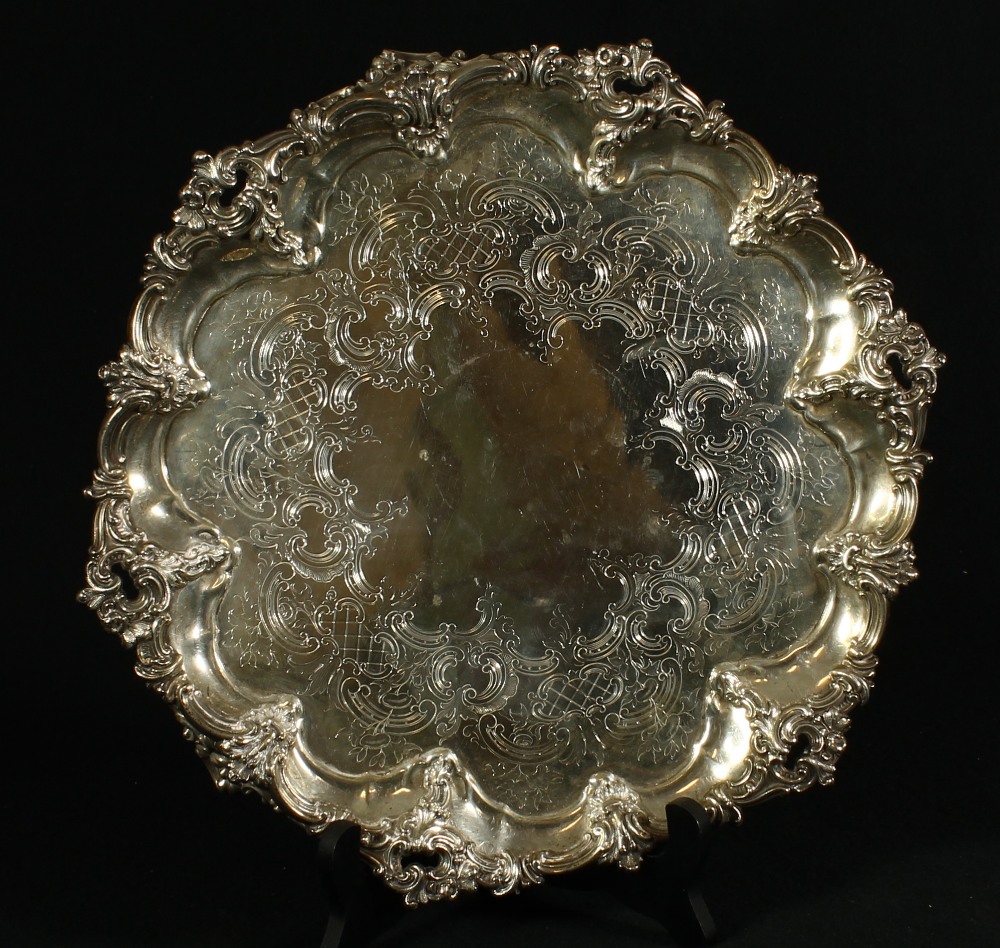 Victorian silver salver of circular form decorated in the rococo manner with relief edge of C