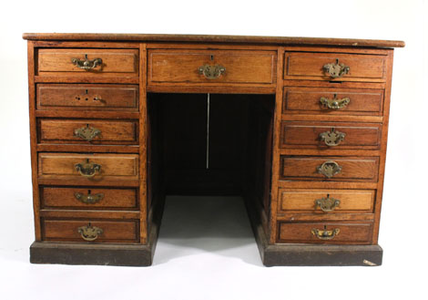 An oak pedestal desk of thirteen drawers with panelled front and sides, w. 123 cm    CONDITION