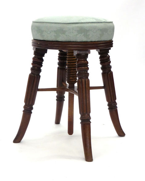 A William IV mahogany stool, the rising upholstered top on turned and reeded legs, joined by an '