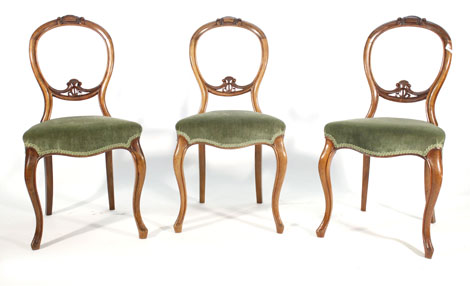 A set of four Victorian walnut framed dining chairs with moulded balloon backs on cabriole legs
