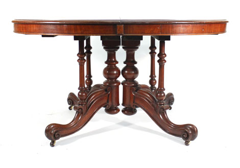 A Victorian walnut extending dining table, the moulded top with 'D' shaped ends on scroll moulded