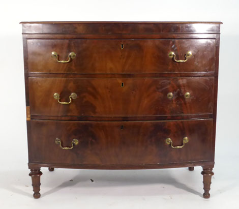 A 19th century mahogany bow fronted chest of three long drawers on turned legs, w. 100 cm